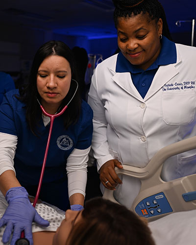 Student nurse and professor working in nursing lab