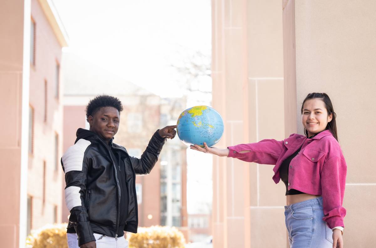 Students holding a globe