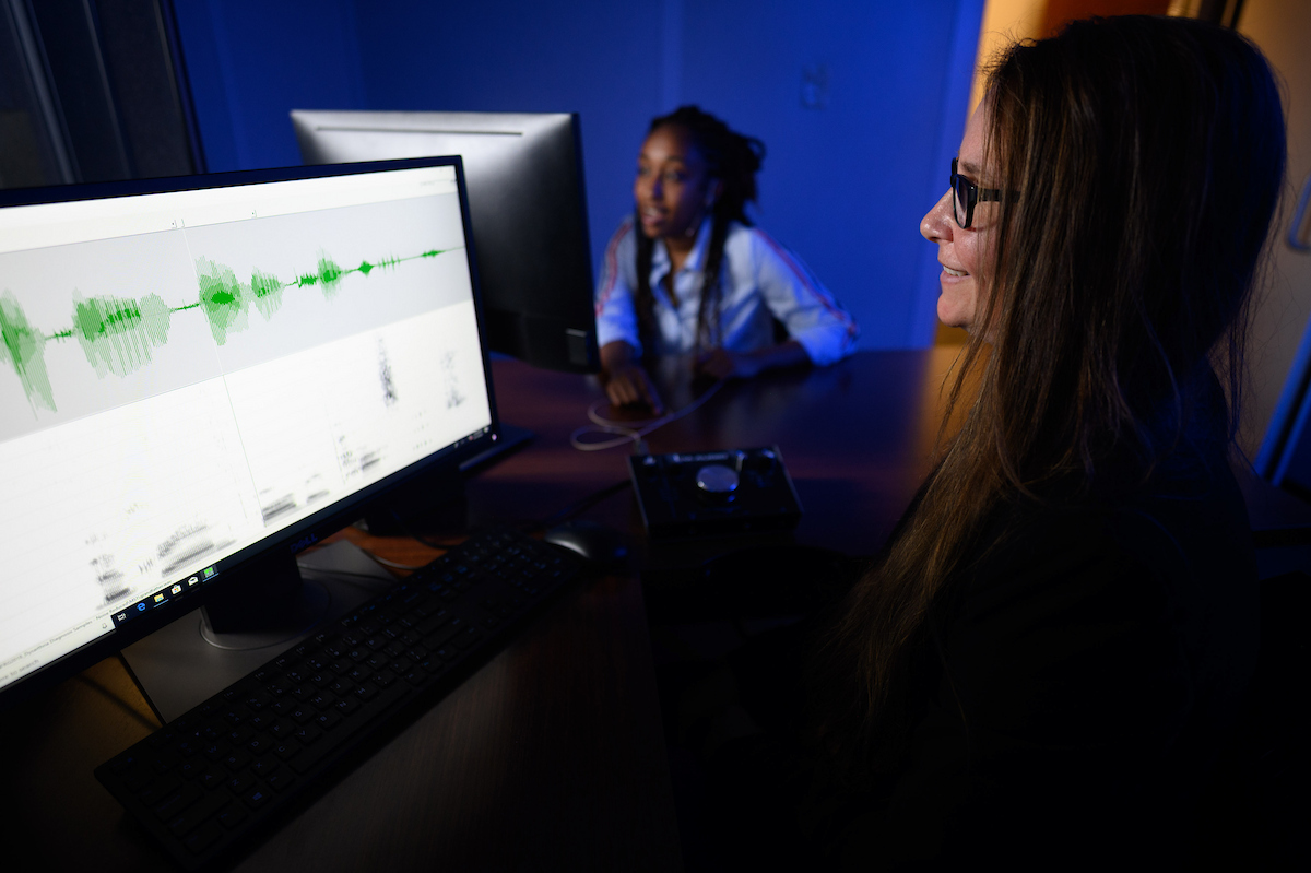 Speech Language Pathology students in research lab looking at data and audio recordings