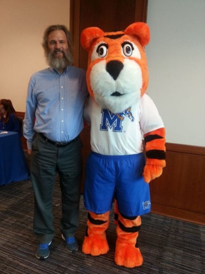 Ed Brainerd standing with UofM Mascot