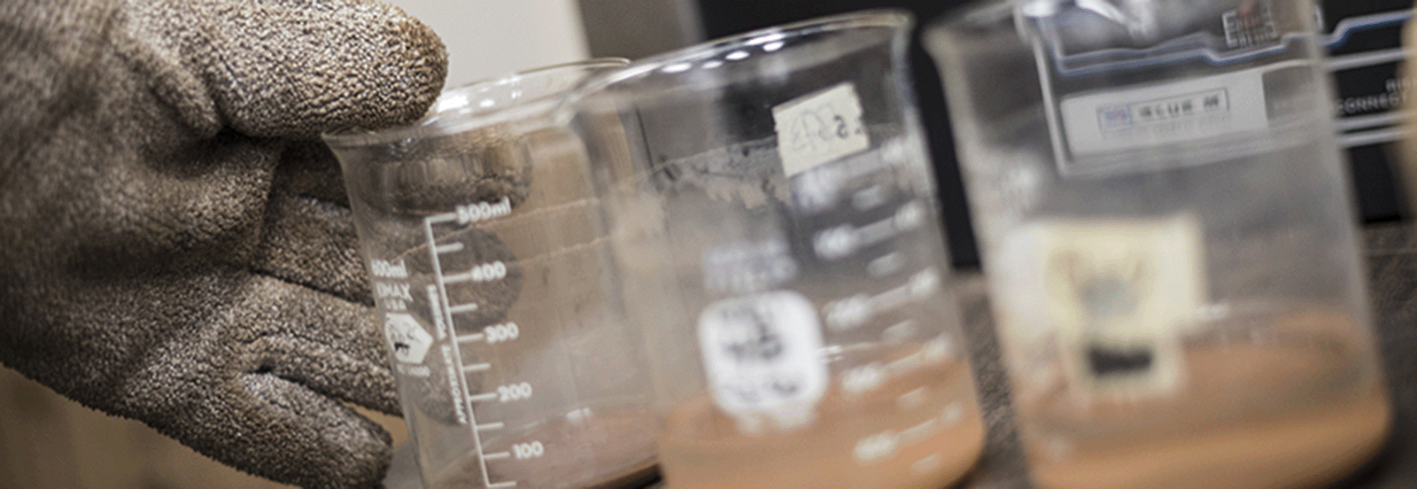 Soil analysis – student taking beakers out of oven during soil analysis
