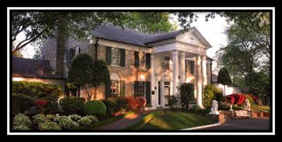 A picture of Elvis Presley's former home at Graceland. It is a white two-story house with columns on the front with a few trees and very well-maintained garden around it.