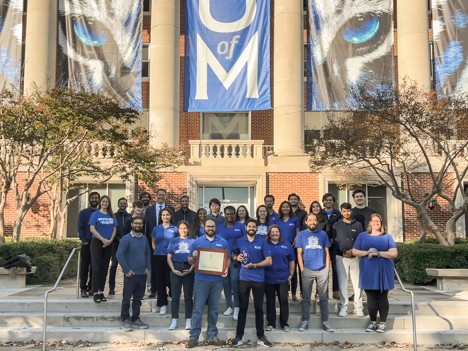 CAESER staff posing for photo with award outside the Administration Building on the UofM campus.