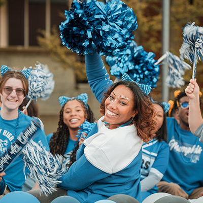 Homecoming parade participants wave and smile