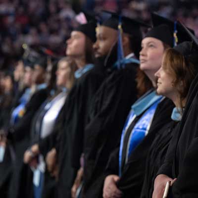 UofM students in cap and gown at commencement ceremony