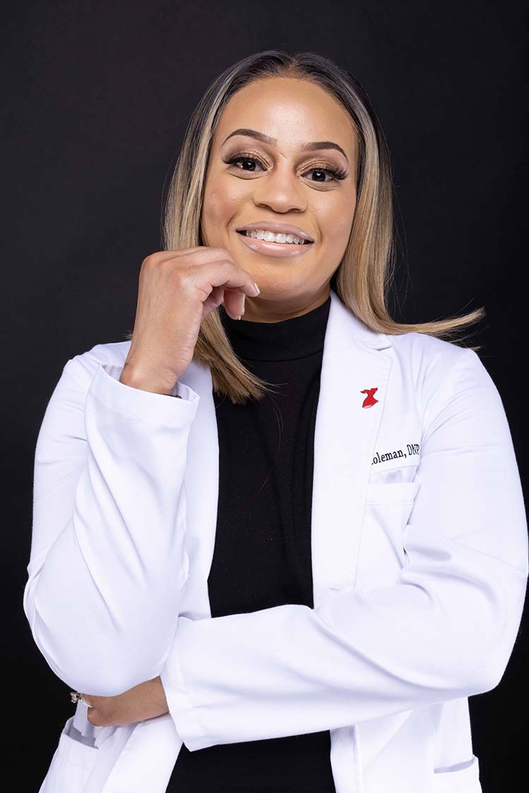 Ashanti Coleman in white coat, smiling