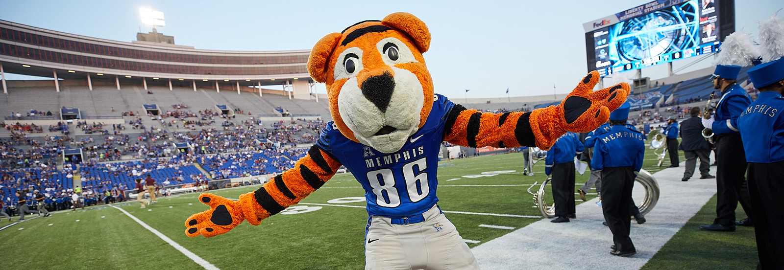 Pouncer standing on the sideline at the football stadium with arms wide