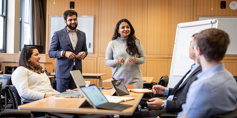 Five professionals working in a boardroom