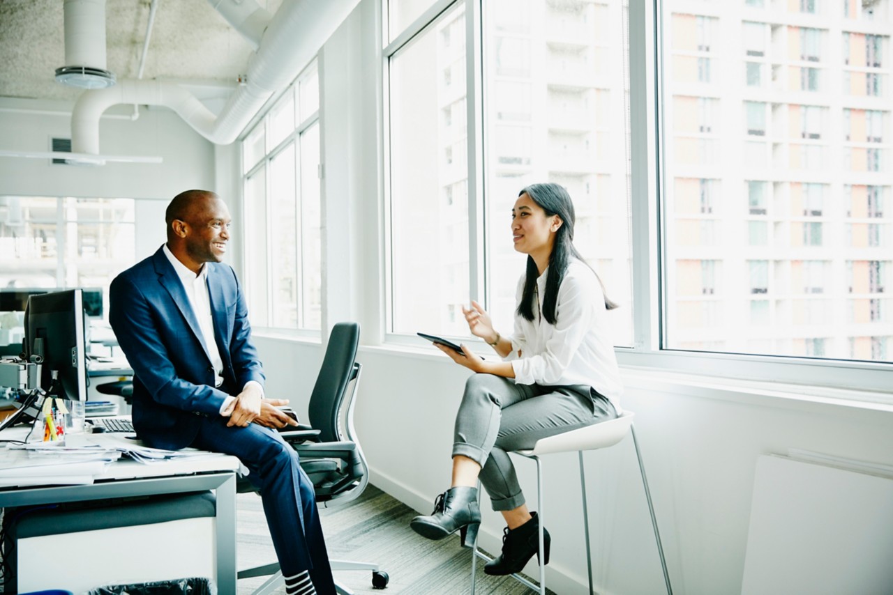 Two individuals in an office discussing healthcare access