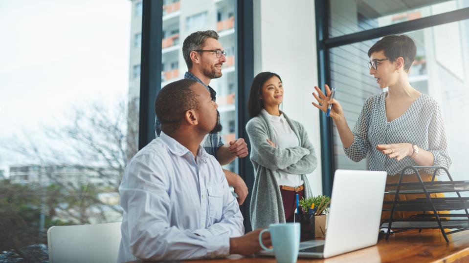 Group discussing topic around an office desk