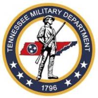 Seal of the Tennessee Military Department featuring a colonial-era soldier holding a rifle, standing in front of the outline of the state of Tennessee with the Tennessee tri-star emblem. The circular border reads ‘Tennessee Military Department’ with the year ‘1796’ at the bottom and stars around the edge.